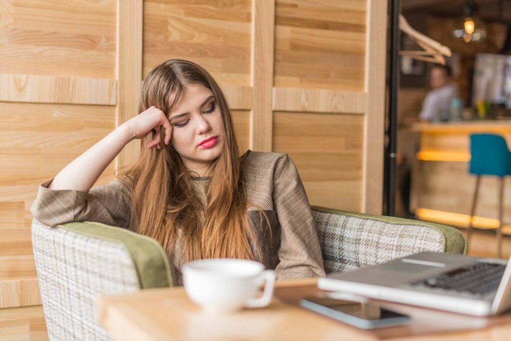 woman sitting in a cafe looking upset - therapy